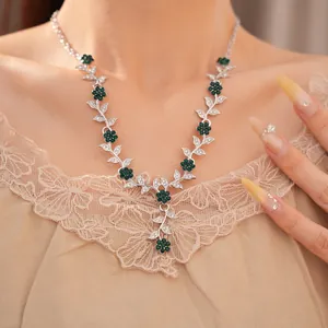 Elegant vintage silver-toned necklace with intricate green rhinestone flower and leaf detail