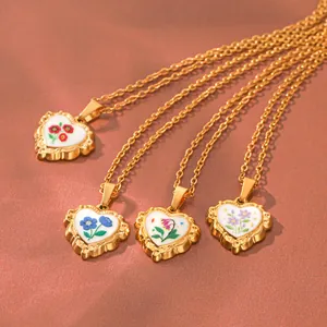 Vue détaillée de quatre colliers pendentif cœur en émail avec bordure dorée festonnée
