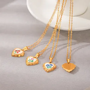Vue détaillée de pendentifs cœur en émail avec des motifs floraux colorés en finition or 18k