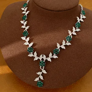 Macro view of vintage silver necklace with green crystal floral and leaf details
