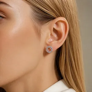 Nahaufnahme von funkelndem hohlem Kreis-Ohrstecker mit rosa Kristallen am Model