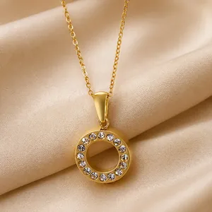 Nahaufnahme einer eleganten goldenen Halskette mit hohlem Kreisanhänger und Kristallen.