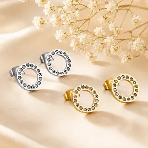 Detailansicht von kreisförmigen Ohrsteckern in Gold und Silber mit glitzernden Steinen.