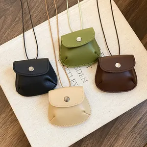 Gedetailleerd overzicht van vier kleurrijke retro lederen mini tas kettingen op een boek