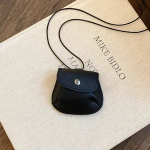 Gedetailleerde weergave van een vintage zwarte leren tasje hanger ketting met drukknop