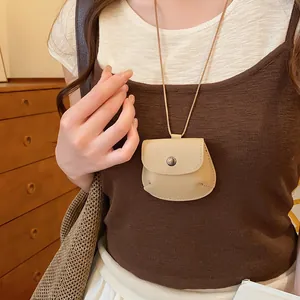 Detailweergave van een beige retro lederen sleuteltas hanger ketting op een model