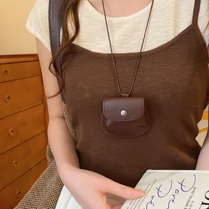 Model draagt een vintage bruine leren mini tasje hanger ketting voor dames