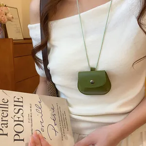Detail van een vintage groene lederen mini tas hanger ketting gedragen door model