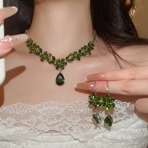 Detailaufnahme eines luxuriösen Schmucksets mit grünem Zirkon und Blumenanhänger
