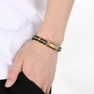 Gros plan d'un bracelet pour homme en cuir tressé noir avec une plaque dorée courbée