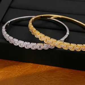 Elegant 18K gold and silver plated zircon square link bangles displayed on a black stand