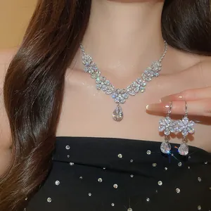 Nahaufnahme von luxuriösem Schmuckset mit Blumen-Zirkonia-Halskette und passenden Ohrringen