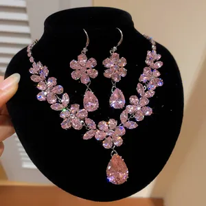 Nahaufnahme eines funkelnden rosa Zirkon-Blumenschmucksets mit Kette und Ohrringen.