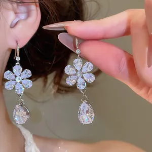 Nahaufnahme funkelnder Blumen-Ohrhänger mit klarem Zirkonia-Tropfen für luxuriöse Abendmode