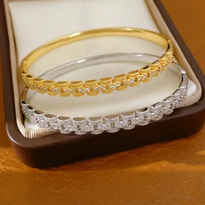 Detailopname van 18K goudvergulde armbanden met zirkonia in een doosje