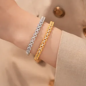 Close-up van luxe 18K vergulde vierkante schakelarmbanden met zirkonia op de pols gedragen