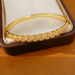 Detailopname van 18K vergulde armband met sprankelende vierkante zirkonia stenen