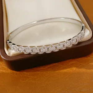 Detail van een zilverkleurige armband met vierkante cubic zirconia en kliksluiting