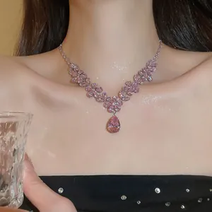 Detailansicht einer luxuriösen Halskette mit rosa Zirkonia-Blumenanhänger am Model