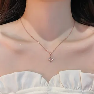 Close-up of a delicate rose gold necklace with a geometric cat's eye stone pendant.