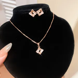 Detail of rose gold jewelry set featuring cat's eye stone geometric rhombus pendants.