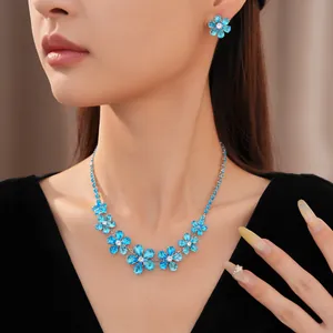 Detailed view of an elegant blue zircon flower necklace and earring set on a model