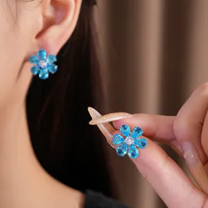 Detailed view of elegant blue zircon flower earrings worn by a model, showing fine craftsmanship