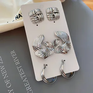 Detailansicht von silbernem Metall-Ohrring-Set mit plissierten und geometrischen Formen