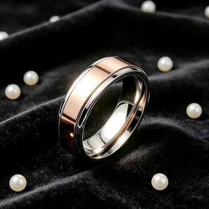 Gros plan d'une bague bicolore en or rose et acier sur un fond de velours noir chic