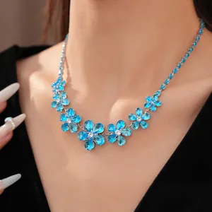 Close-up of elegant blue zircon flower necklace on model's neck for a luxury look.