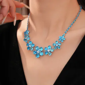 Detailed close-up view of a blue zircon flower necklace worn on a model's neck