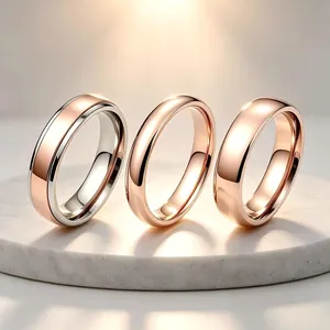 Gros plan de trois anneaux minimalistes en or rose et acier titane poli brillant