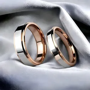 Détail macro de bagues de couple en acier titane bicolore argent et or rose sur soie