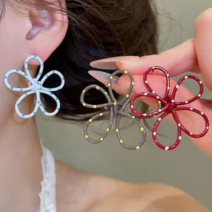 Close-up of hollow flower earrings with polka dot spray paint design in multiple colors.