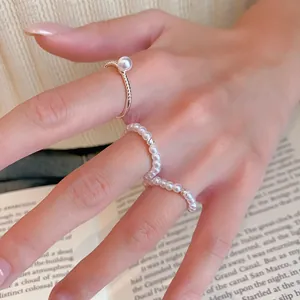 Gros plan d'un ensemble de bagues en perles plaquées or 14 carats, style vintage