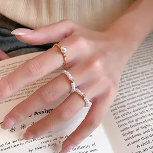 Détail d'un ensemble de bagues en perles plaquées or 14 carats sur un livre ancien.