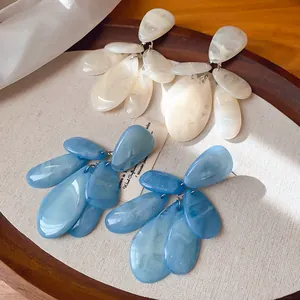 Detailansicht der marmorierten Harz-Ohrringe in Tropfenform in Blau und Creme.
