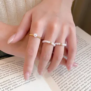 Détail d'un ensemble de bagues en perles plaquées or 14 carats sur fond de livre