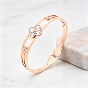 Rose gold stainless steel clover bangle featuring sparkling clear gemstone details.