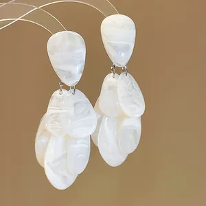 Makroansicht weißer marmorierter Harz-Ohrhänger mit einem eleganten Tropfen-Design