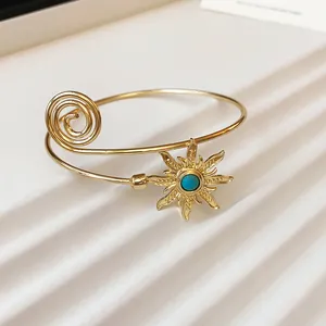 Nahaufnahme eines exotischen goldenen Sonnenblumen-Armreifs mit einem Türkis-Zentrum