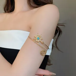 Detailansicht eines vintage goldfarbenen Armreifs mit Sonnenblume und Türkisstein