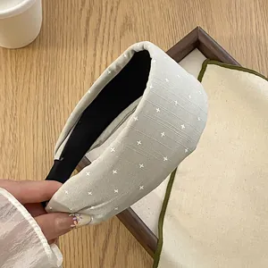 Detailansicht eines breiten, hellgrauen Stoff-Stirnbandes mit kleinen weißen Sternen.