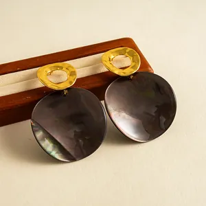 Vue détaillée de boucles d'oreilles rétro avec métal doré et disque en résine irisées