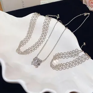 Elegant silver hollow lace choker and ball chain necklace set on a white display tray.