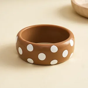 Gedetailleerde weergave van bruine hars armband met witte stippen patroon ontwerpen