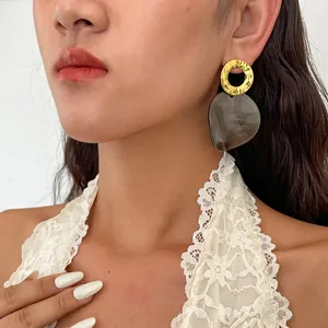Détail d'une boucle d'oreille vintage en métal doré avec pendentif en forme de cœur