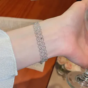 Detailansicht eines silbernen Armbands mit hohler Spitze und funkelnden Akzenten