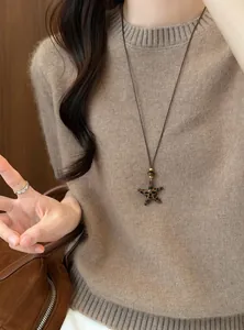 Detailweergave van een luipaardprint sterhanger aan een bruine leren koordketting