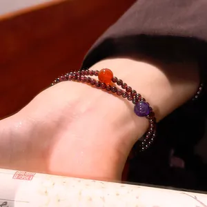Dettaglio ravvicinato del bracciale di granato con accenti di corniola e ametista al polso